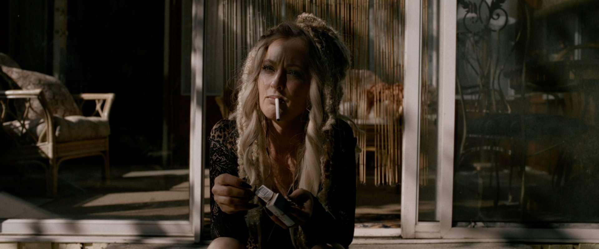 Katharine Isabelle as Vahna with a cigarette in her mouth in the horror film, Lockbox.
