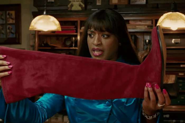 Chiwetel Ejiofor as Lola in Kinkly Boots. Lola holding up a boot.