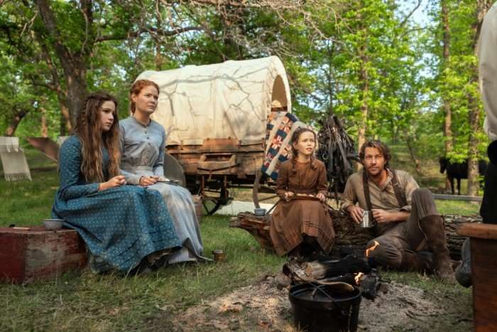 LHOTP_101_Unit_00687RC The family in Netflix's Little House on the Prairie. They sit in a cicle in front of their wagon, filled with their belongings.