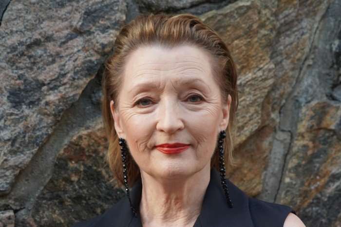 Lesley Manville smiling towards the camera.