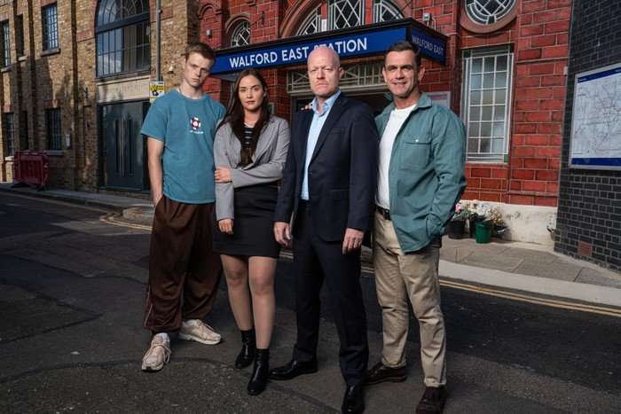 Branning family Pierre Moullier, Jacqueline Jossa, Jake Wood and Scott Maslen in character, stood in front of a tube station looking ahead.