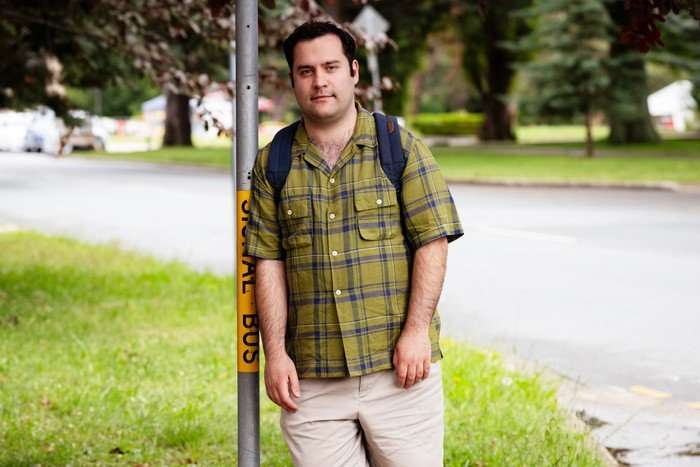 Austin Michael Theo as Austin leaning against a lamp post