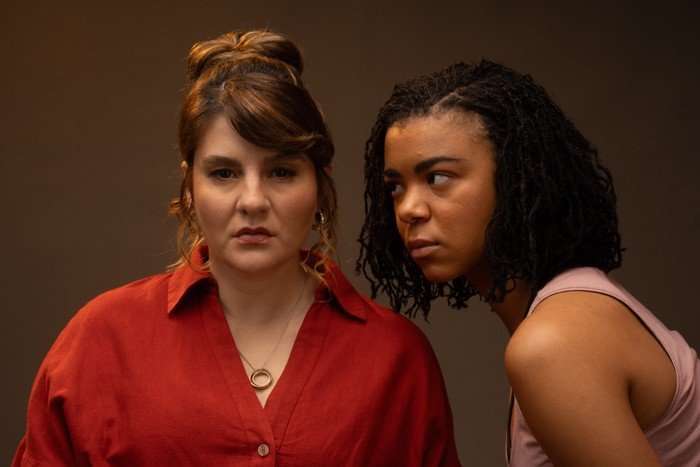 Ruth Madeley The Rapture Ruth Madeley looking at the camera, with India Amarteifio looking towards Ruth, with a dark background