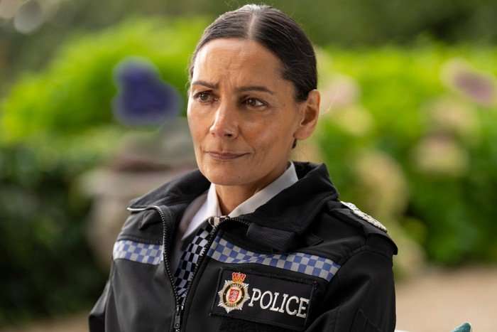 Sasha Behar as Uma Dalal wearing her police uniform, stood outside
