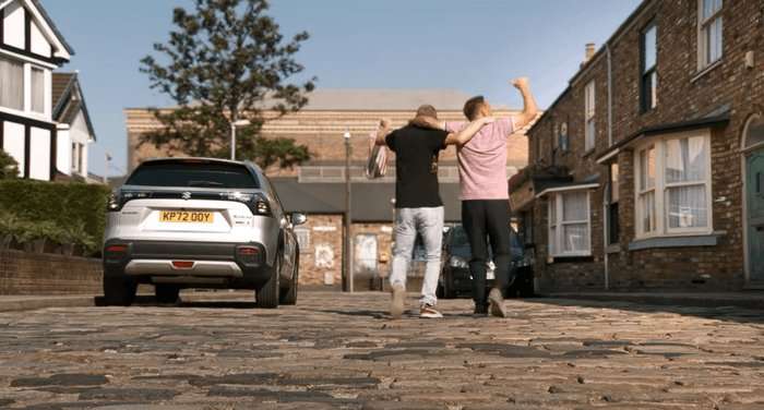 Kirk and Tyrone dance down the cobbles in a scene from Coronation Street
