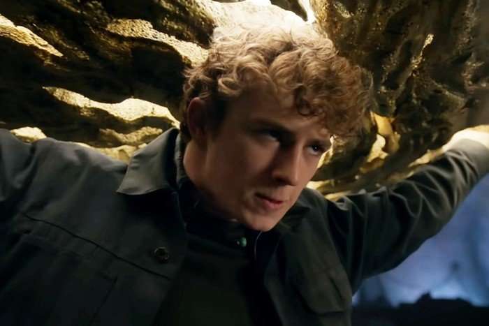 Walker Scobell as Percy in Percy Jackson and the Olympians season 3, holding a huge weight on his back