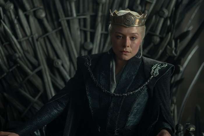 HOUSE OF THE DRAGON emma-d-arcy- Emma D'Arcy as Rhaenyra Targaryen in a crown and sat upon the Iron Throne in House of the Dragon season 3.