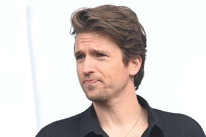 Greg James Close up of Greg James focusing on something off screen, with a neutral white background.