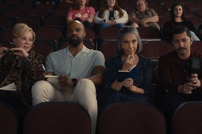 hacks-jean-smart-carl-clemons-hopkins-rose-abdoo-mark-indelicato (L-R) Jean Smart, Carl Clemons-Hopkins, Rose Abdoo and Mark Indelicato star in Hacks season 5; their characters are sat in theatre seats waiting for a show to start