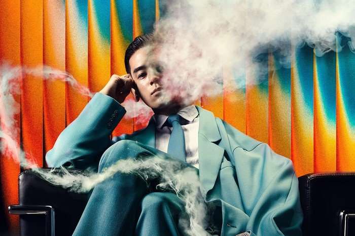 Human Vapor on Netflix Ren Tsutsumida in Human Vapor, sitting in a blue suit and with steam emerging from the side of his head.