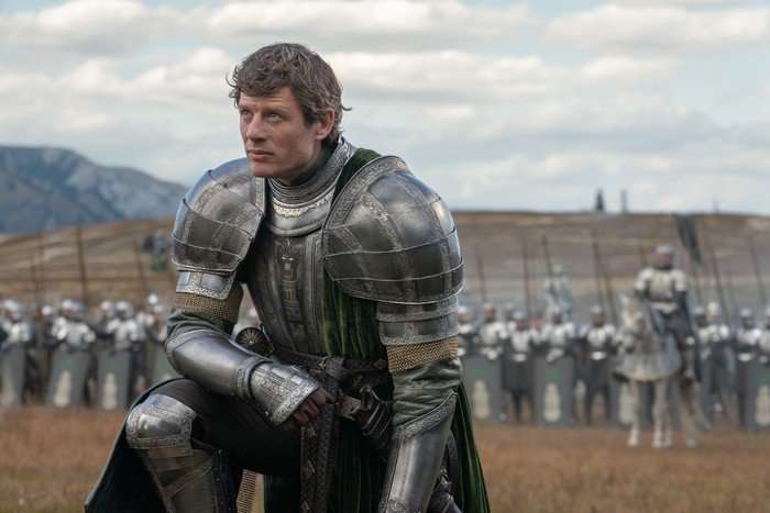 HOUSE OF THE DRAGON james-norton (1) James Norton bows in armour on a field as Lord Ormund Hightower in House of the Dragon season 3.
