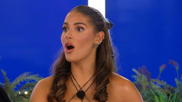 Love Island S13 Mica sat back looking shocked as she looks over at someone.