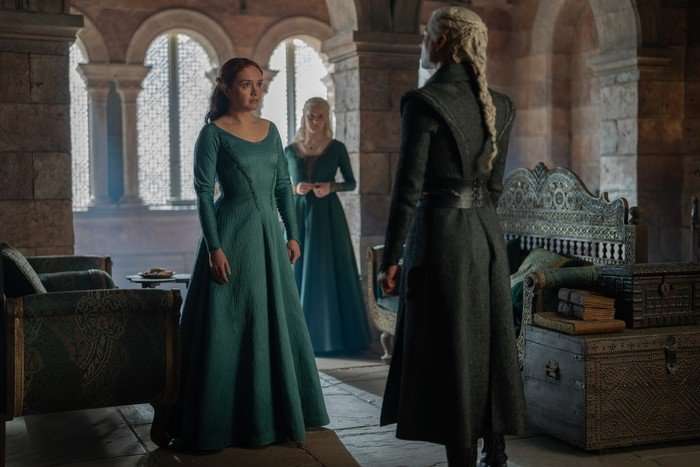 HOUSE OF THE DRAGON olivia-cooke-phia-saban-emma-d-arcy- Olivia Cooke with Phia Saban behind her looks at Emma D'Arcy in a scene from House of the Dragon.
