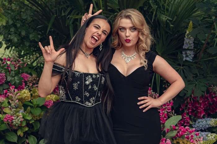 Sahar and Imogen pose for a light-hearted photo while wearing black dresses at their school's end-of-year party