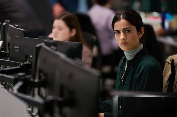 The Undeclared War - Series 2 Ep1 Hannah Khalique-Brown as Saara Parvin, seated among rows of computer monitors in a busy intelligence operations centre in The Undeclared War.